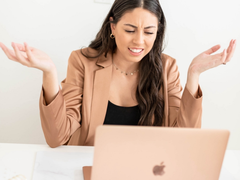 confused woman looks at laptop